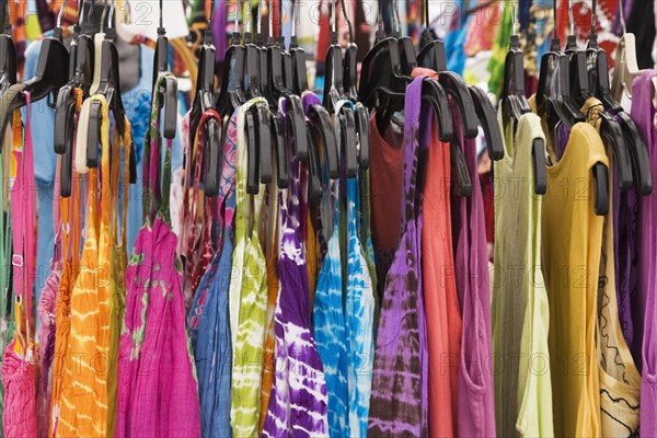 Women's cotton dresses for sale on a clothes rack at an outdoor market