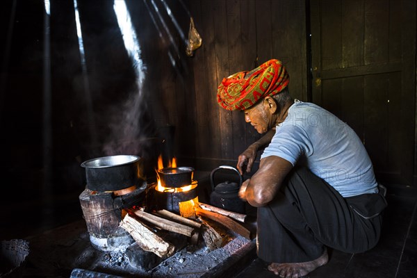 Elderly man at an open fire in the hut