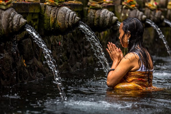 Woman praying in a purifying pool
