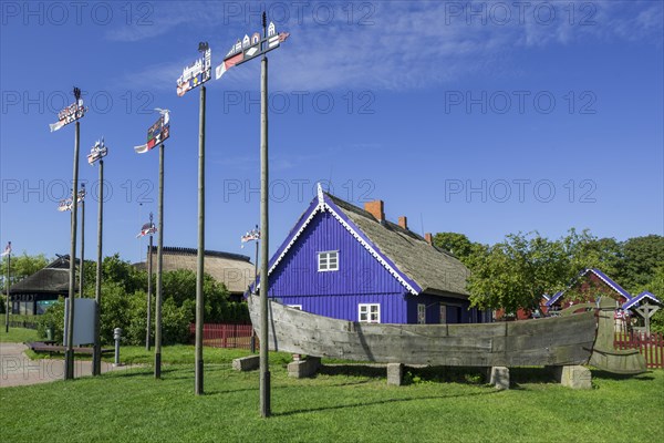 Curonian flags in front of traditional wooden houses