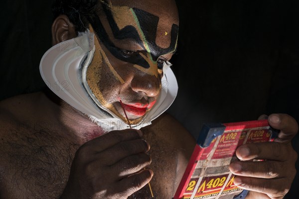 Katakali artist applying the makeup of the Shiva character