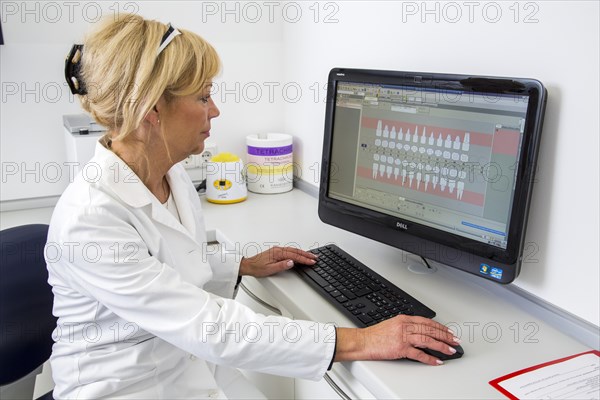 Dental assistant entering a patient's data into the electronic medical record