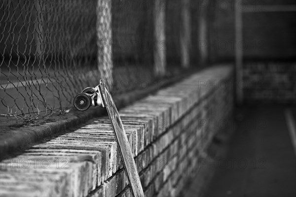 Longboard leaning against brick wall