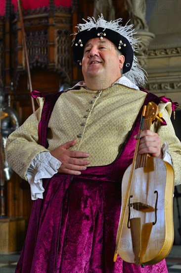 Musician in period costume performing on a medieval fiddle