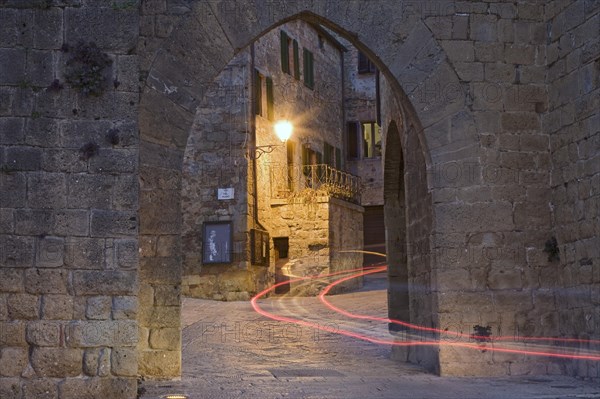 City gate with the light trace of a passing car