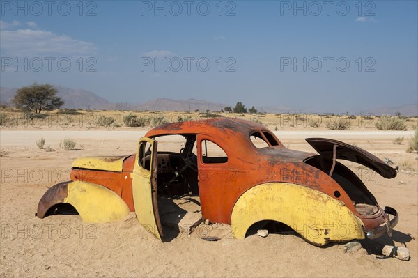 Old car wreck stuck in the sand