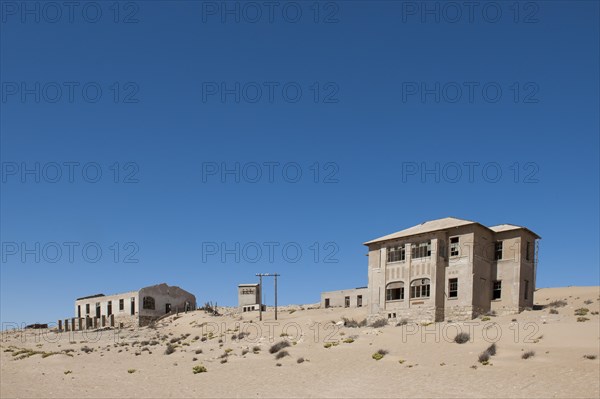 Houses of a former diamond miners settlement that is slowly covered by the sand of the Namib Desert