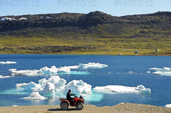 Man of the Inuit people riding a quad bike