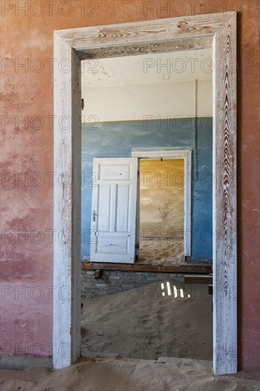 Wind-borne sand in a house of the former diamond miners settlement that is slowly covered by the sand of the Namib Desert