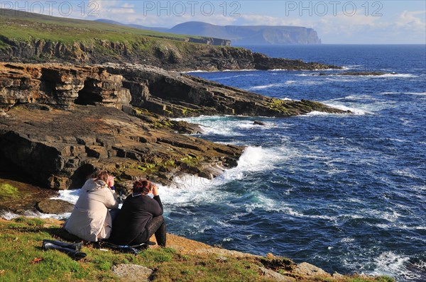 Two female tourists on the lookout with binoculars