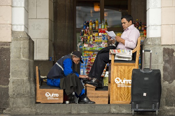 Shoeshine boy serving a client