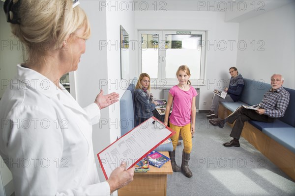 Receptionist calling for the next patient in the waiting room of a dental office