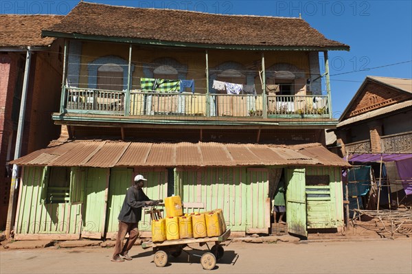 Man pushing goods on home-made cart