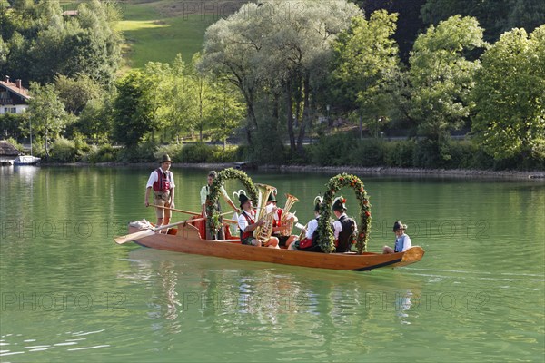 Locals wearing traditional costumes in a decorated wooden Platte boat