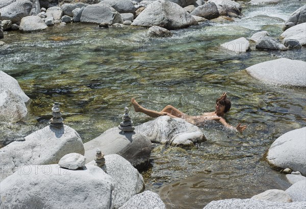 Woman bathing in the mountain river of Maggia