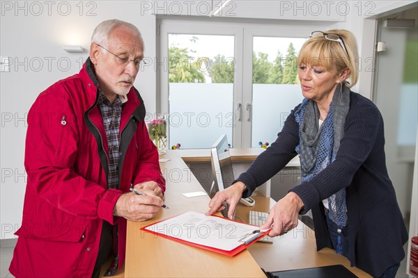 Patient filling in a form at the reception of a dental office