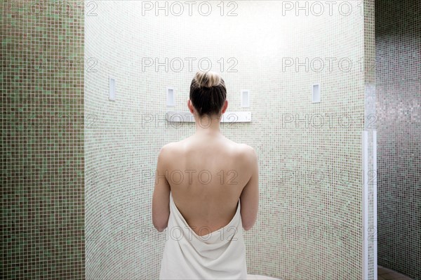 Woman standing in a steam room of a spa complex
