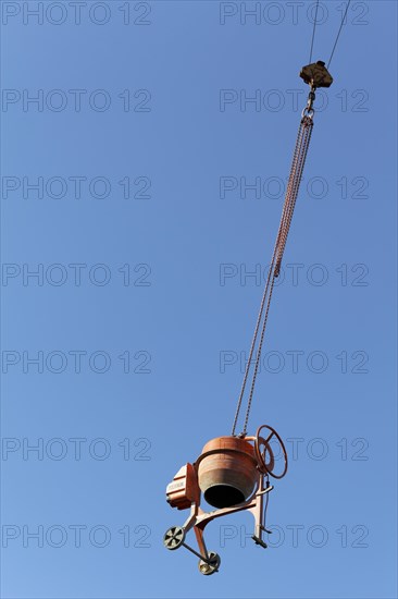 Concrete mixer hanging from a crane