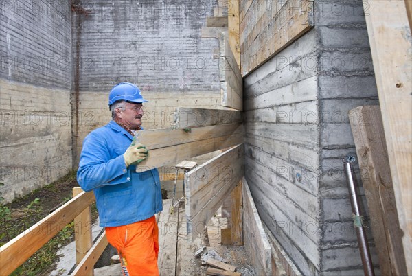 Man doing concrete restoration and construction work on the main building of the HSG University of St. Gallen