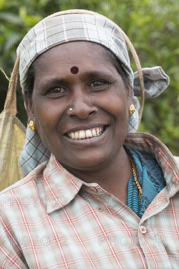 Tea picker wearing gold jewelry and a hat