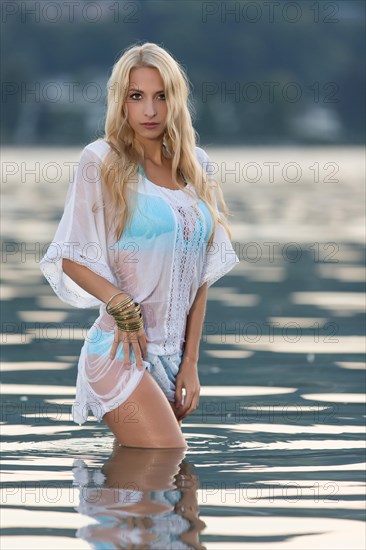 Woman wearing a light blue bikini under a white transparent shirt