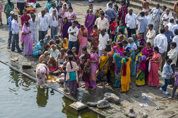 A family and a pandit or priest are performing Dashkriya or Asthi Visarjan