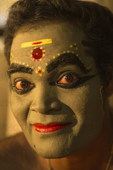 Kathakali dancer in full makeup waiting for his performance