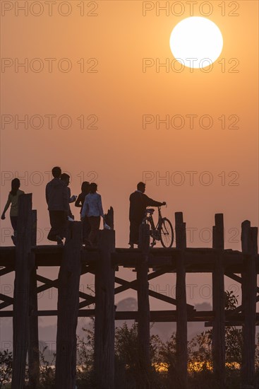 Locals and tourists walking on a teak bridge