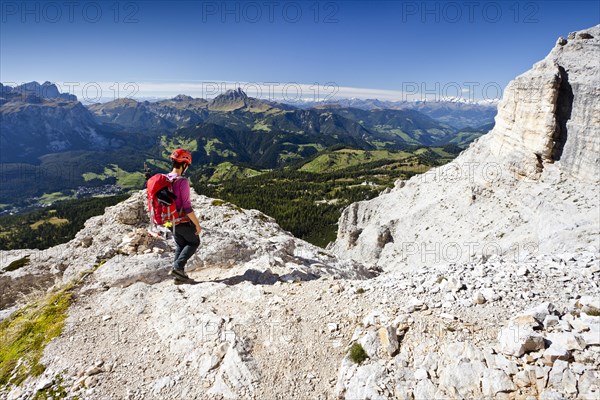 Mountain climber descending from Heiligkreuzkofel Mountain along the Heiligkreuzkofelsteig climbing route in the Fanes Group in Fanes-Sennes-Prags Nature Park