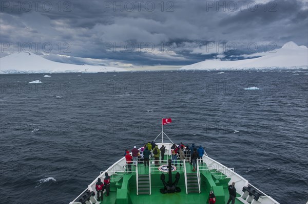 Ship heading towards glaciers and dark clouds