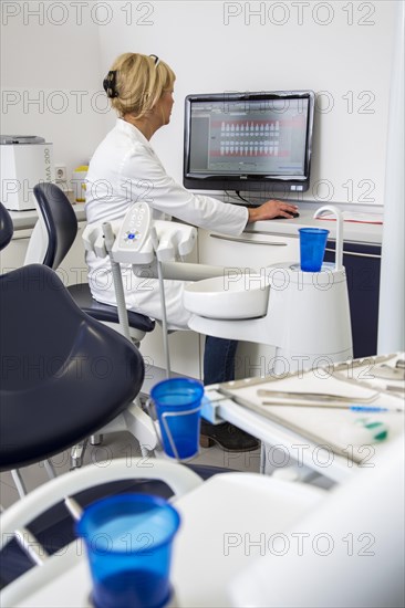 Dental assistant entering a patient's data into the electronic medical record