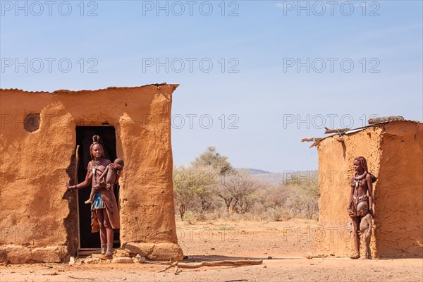 Himba women with children in front of their mud huts