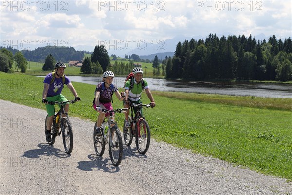 Cyclists on bike tour on Luimooser Weiher pond in Seeg