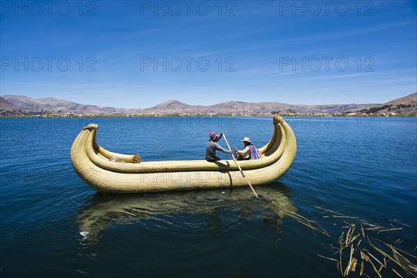 Two local in a traditional rowing boat of Totora reed on Lake Titicaca