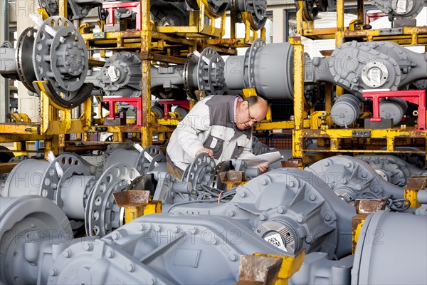 Worker checking truck drive axles from MAN Truck and Bus AG