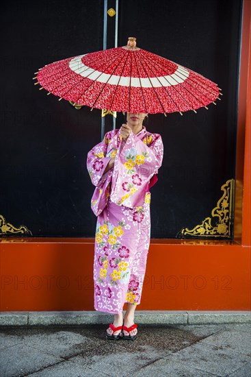 Young woman in kimono and with oil-paper umbrella