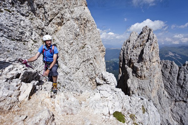 Mountain climber ascending Plattkofel mountain along the Oskar-Schuster Stieg climbing route