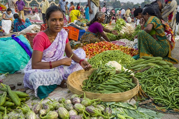 A woman is selling vegetables at the weekly vegetable market