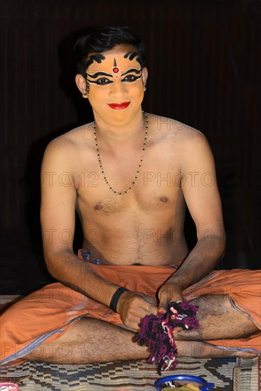 Kathakali dancer applying makeup in preparation for his performance