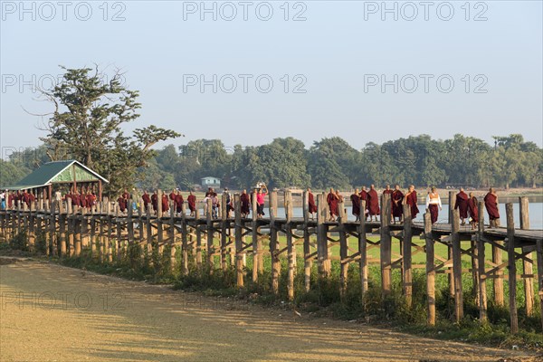 Locals and monks on a teak bridge