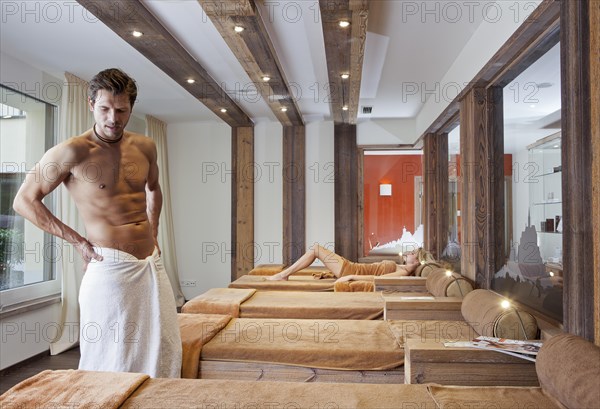 Man and woman relaxing in the relaxation area of a sauna