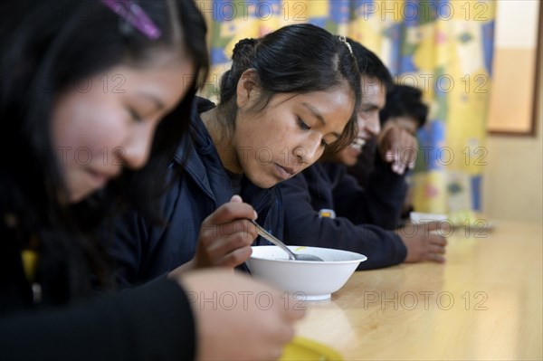 Teenagers eating in the cafeteria of their school