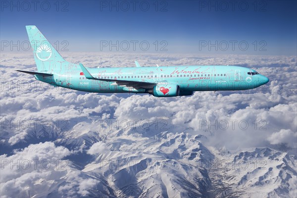 SunExpress Boeing 737 in flight over mountains