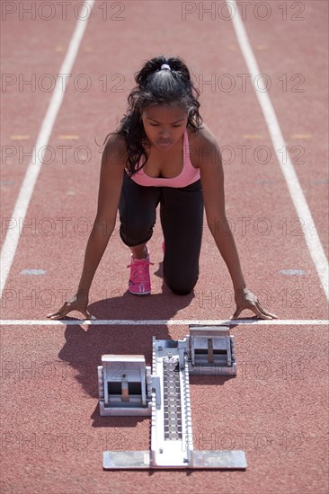 Sporty young woman getting ready on running track