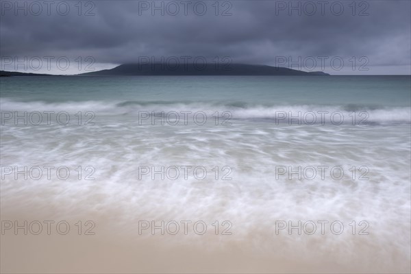 Mount Ceapabhal veiled by dark rain clouds on the horizon