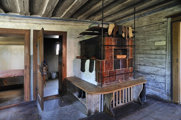 Living room with a tiled stove in a farmhouse