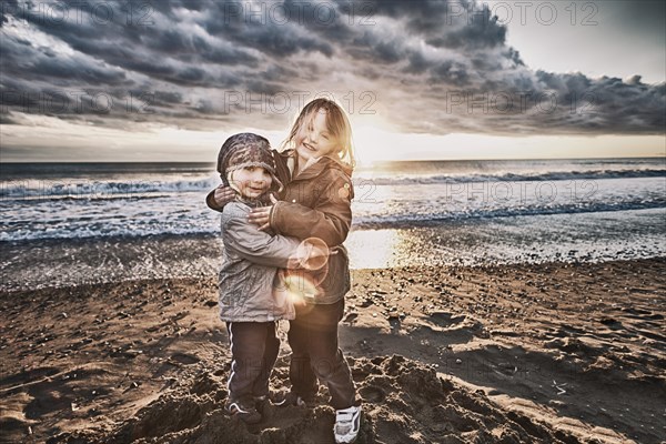 Two girls standing on the beach