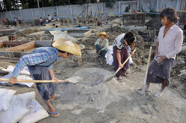 Children and teenagers mix concrete on a high rise construction site