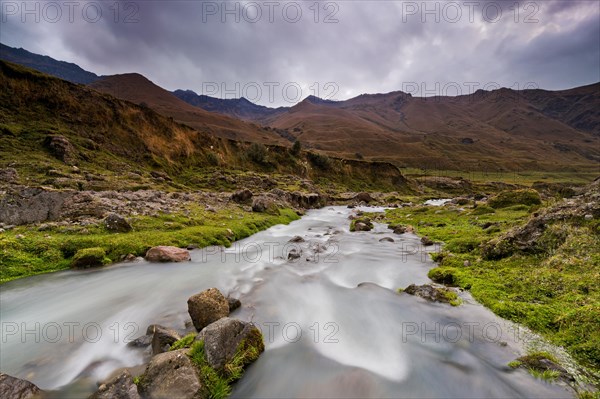 Mountain stream with the peaks of El Altar or Kapak Urku