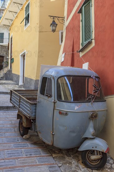 Typical Italian three-wheeled light commercial vehicle parked in an alley